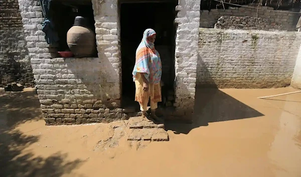 A woman checks her damaged house in the aftermath of floods in Charsadda district, Khyber Pakhtunkhwa province, Pakistan. Photograph: Arshad Arbab/EPA