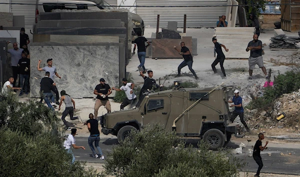 Palestinians hurl rocks at Israeli occupation vehicles during an Israeli raid in the West Bank village of Rujib, Palestine Tuesday, Aug. 30, 2022 (AP Photo/Majdi Mohammed)