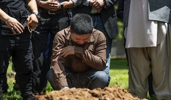 Altaf Hussain cries over the grave of his brother Aftab Hussein at Fairview Memorial Park in Albuquerque on Aug. 5, 2022. (AP))