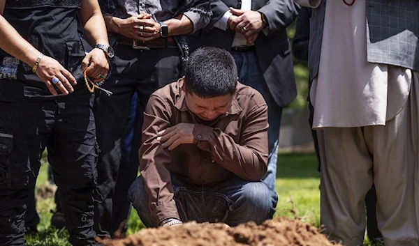 Altaf Hussain cries over the grave of his brother Aftab Hussein at Fairview Memorial Park in Albuquerque, N.M., on Friday, Aug. 5, 2022. (AP)