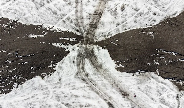 Hikers walk past the newly uncovered Zanfeluron path, as a split of the Sex-Rouge and the Zanfleuron Glacier revealed the path for the first time in 2000 years due to this summer heatwave, at Glacier 3000 in Les Diablerets, Switzerland, September 11