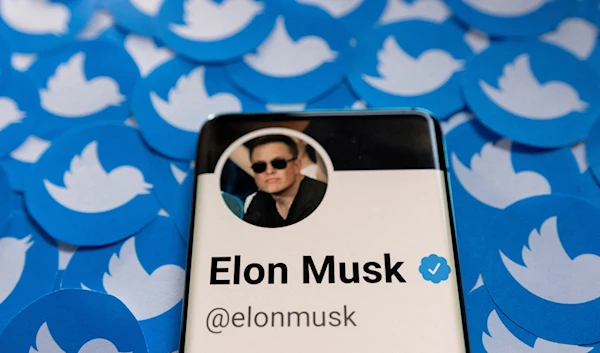 Elon Musk's Twitter profile is seen on a smartphone placed on printed Twitter logos in this picture illustration taken April 28, 2022 (Reuters)