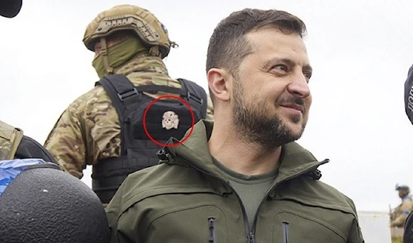 Image released from the Ukrainian presidency's official page, showing the bone-and-skull Nazi insignia patched on the guard's back.