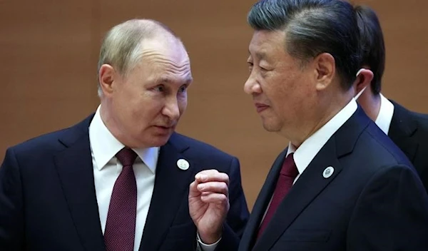 Russian President Vladimir Putin speaks to China's President Xi Jinping during the Shanghai Cooperation Organization (SCO) leaders' summit in Samarkand on September 16, 2022. (AFP)