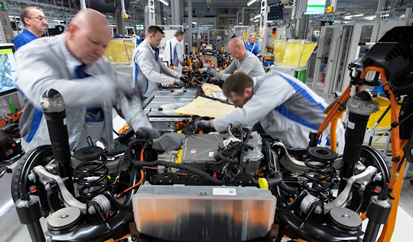 Workers complete an electric car ID.3 body at the assembly line during a press tour at the plant of the German manufacturer Volkswagen AG (VW) in Zwickau, Germany, Tuesday, Feb. 25. 2020 (AP Photo/Jens Meyer, file)