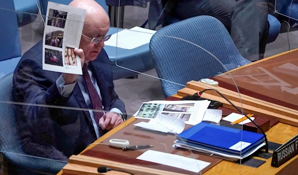 Russian Ambassador to the United Nations Vassily Nebenzia showing docuemtns during an emergency meeting of the United Nations Security Council on 10 March, discussing alleged biological weapons in Ukraine (AFP)