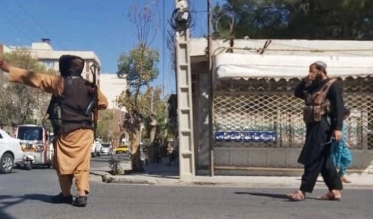 Taliban fighters block a road after the blast during Friday prayers in Gazargah Mosque, the largest in Herat [AFP]