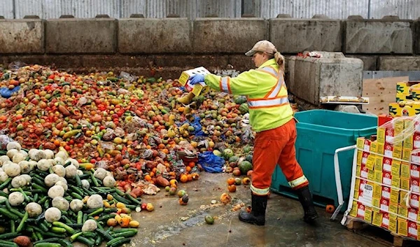 A worker dumps pre-consumer food waste. (Archive)