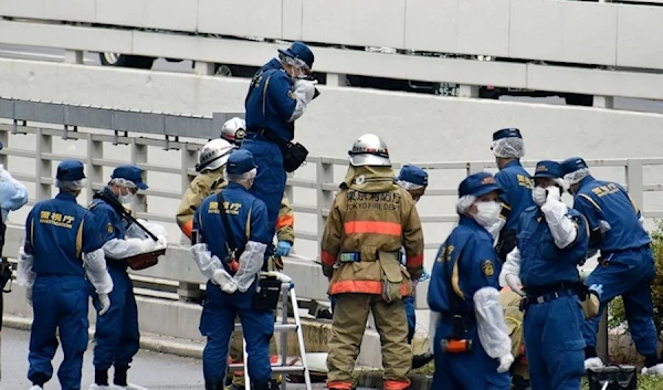 Police and firefighters at the scene where a man is reported to set himself on fire. (AP)