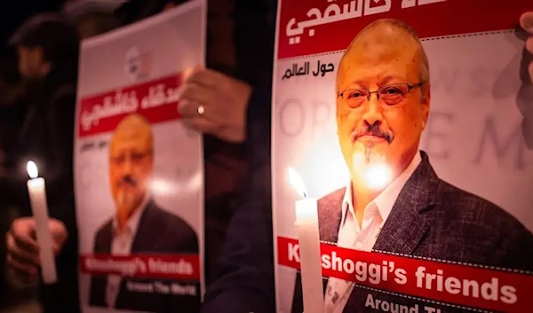 People hold posters picturing Saudi journalist Jamal Khashoggi and lightened candles during a gathering outside the Saudi Arabia consulate in Istanbul, on October 25, 2018. Yasin Akgul/Getty Images.