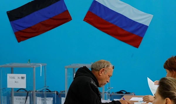 A man fills in documents at a polling station during a referendum on the joining of the Donetsk People's Republic (DPR) to Russia. (Reuters)