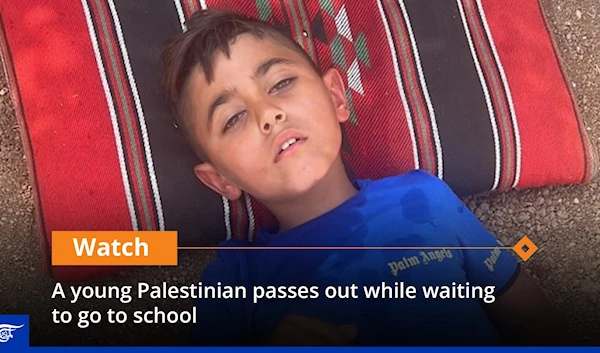 A young Palestinian passes out while waiting to go to school