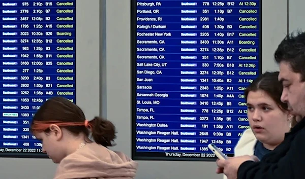 Travelers look over departure notifications in Chicago. (REUTERS)