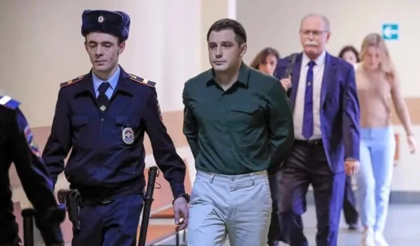 Trevor Reed, center, at a court hearing in Moscow in 2020. During one hearing, Mr. Reed said the case against him was political and linked his troubles in Russia to his military affiliation. (Reuters)