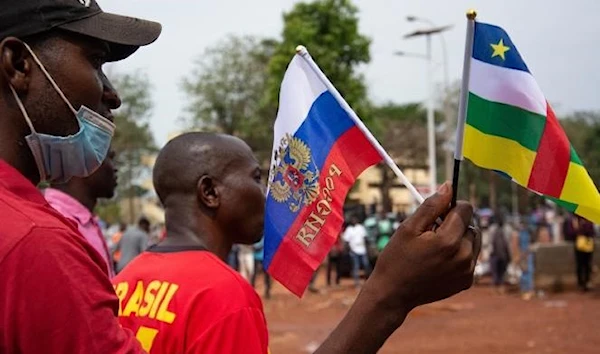 Two individuals holding the flags of Central African Republic and Russia during a demonstration in support of Russia, in Bangui, March 5, 2022 (AFP).