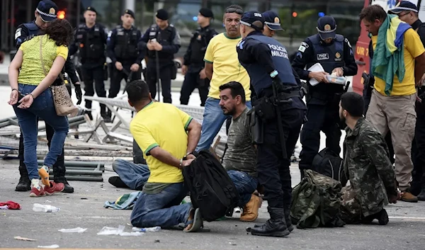 Brazilian Security forces arrest supporters of former President Jair Bolsonaro after retaking control of Planalto Presidential Palace in Brasilia, Brazil, on January 8, 2023 (AFP).