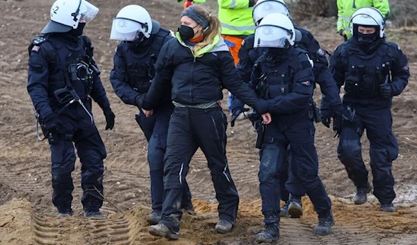 A detained activist is led away by police officers, as activists demonstrate at Luetzerath, a village that is about to be demolished to allow for the expansion of the Garzweiler open-cast lignite mine of Germany's utility RWE, Germany, January 10, 2023.