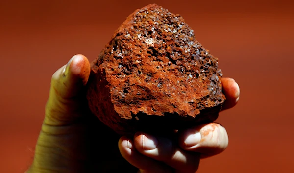 A miner holds a lump of iron ore at a mine located in the Pilbara region of Western Australia December 2, 2013 (Reuters).