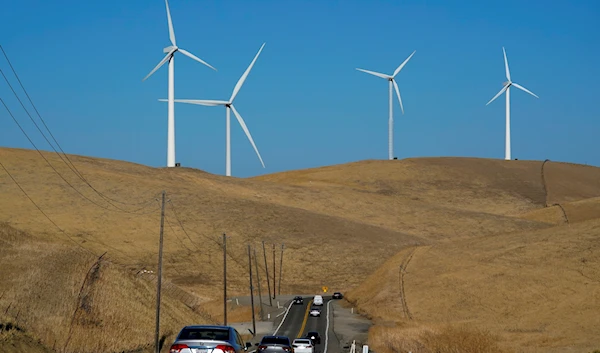 Vehicles move down Altamont Pass Road with wind turbines in the background in Livermore, Calif., Aug. 10, 2022 (AP Photo/Godofredo A. Vásquez, File)