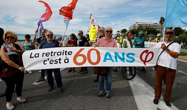 Protestors hold a banner which reads "Retirement is at 60" pension reform demonstration in Nice, France, September 29, 2022 (Reuters).