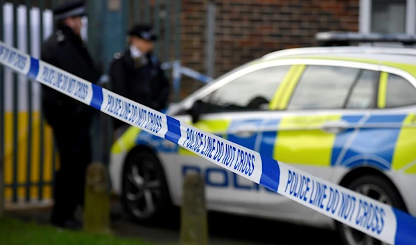 UK Police officers stand outside closed off scene (Reuters)