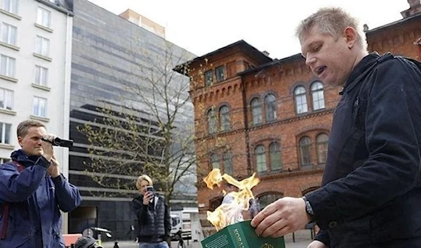 Leader of the anti-immigration and anti-Islam group Hard Line, Danish-Swedish right-wing extremist Rasmus Paludan burns a Koran at the Northern Railway Square (Norra Bantorget) in Stockholm (AFP)