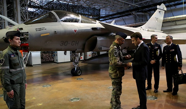 French President Emmanuel Macron talks a soldier as he visits the Mont-de-Marsan air base, southwestern, Friday, Jan. 20, 2023, France (AP Photo/Bob Edme, Pool)