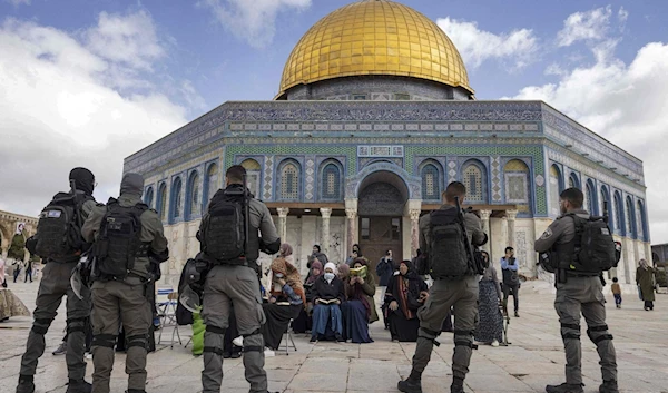 Israeli occupation soldiers stand in front of the Dome of the Rock as settlers storm the area, April 20, 2022 (AFP)