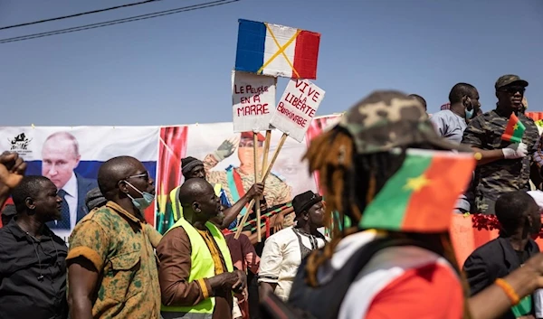 A demonstrator holds placards during a protest to support Burkina Faso President Captain Ibrahim Traore and to demand the departure of France's ambassador and military forces, in Ouagadougou, on January 20, 2023. (AFP)