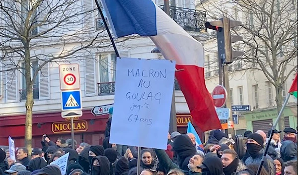 Protestors in France raise a sign in criticism of President Emmanuel Macron's pension reform plan (Social Media)