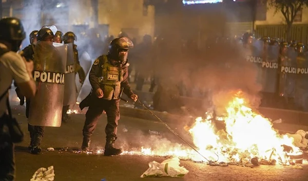 Police clearing a street in the capital of Lima (AP)