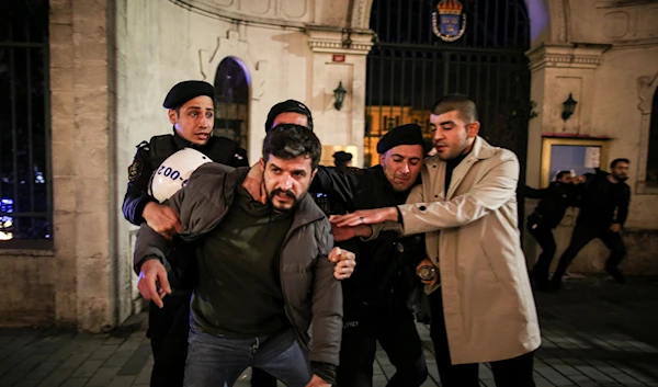 People scuffle with Turkish police officers during a small protest outside the Swedish consulate in Istanbul, Turkey, Saturday, Jan. 21, 2023 (AP Photo/Emrah Gurel)