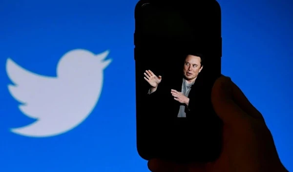 An illustration photo shows a phone screen displaying a photo of Elon Musk with the Twitter logo shown in the background, in Washington. (AFP)