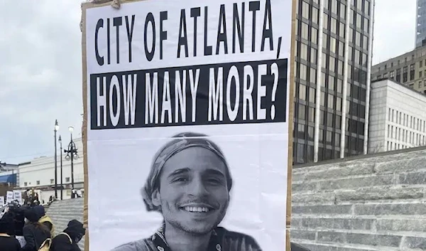 A demonstrator holds a sign protesting the death of an environmental activist, in Atlanta on Saturday, Jan. 21, 2023. (AP Photo)