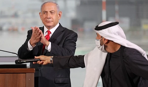 Israeli occupation Prime Minister Benjamin Netanyahu claps during a ceremony welcoming passengers on a flight operated by UAE airline flydubai to Ben Gurion Airport, occupied Palestine, November 26, 2020 (AFP)