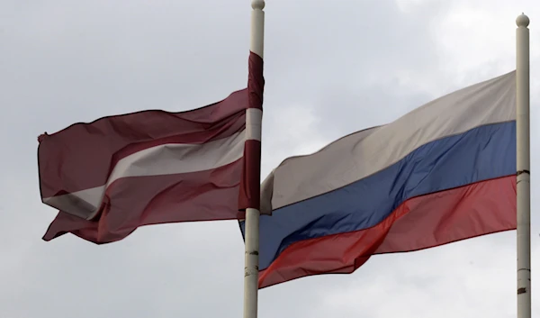 A Latvian flag flutters in the wind next to a Russian flag near a hotel in Daugavpils March 21, 2014. (REUTERS)