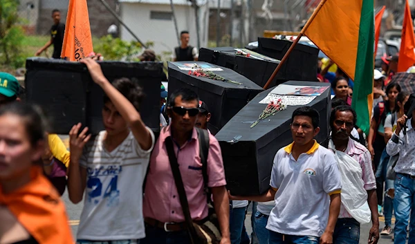 Protestors carrying makeshift coffins of the activists killed in Colombia, in 2018 (AFP)