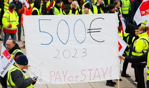 Demonstrators hold a banner during a general strike by employees over pay demands, at the Berlin Brandenburg Airport (BER), in Schoenefeld near Berlin, Germany January 25, 2023 (Reuters).