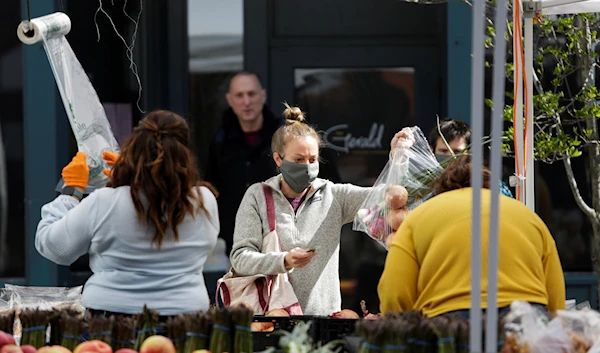 A customer pays for produce at the Ballard Farmers' Market in Seattle, Washington, US April 19, 2020 (Reuters)