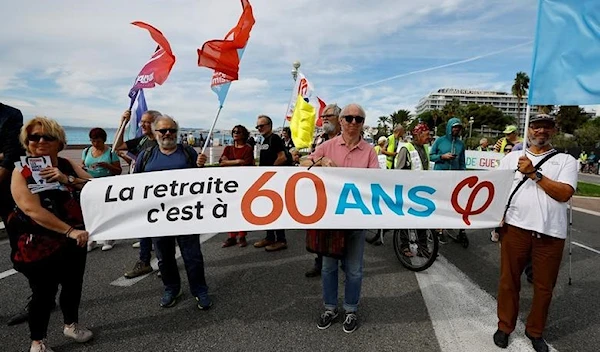 Protestors hold a banner that reads retirement is at 60 during a demonstration in Nice, France, September 29, 2022 (Reuters)