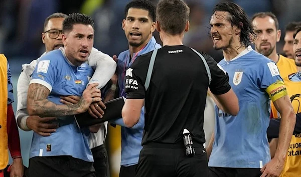 Uruguay's Edinson Cavani, right, argues with referee Daniel Siebert of Germany, at the end of a World Cup group H soccer match against Ghana at the Al Janoub Stadium in Al Wakrah, Qatar, on Dec. 2, 2022 (AP)