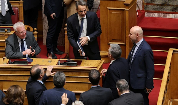 Greek Prime Minister Kyriakos Mitsotakis speaks with members of his government and other lawmakers during a parliamentary debate, in Athens, Greece, January 27, 2023 (Reuters).