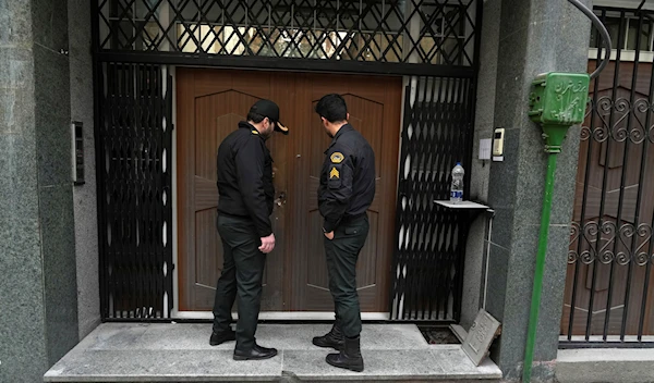 A police officer knocks on the door of the Azerbaijan Embassy in Tehran, Iran, Friday, Jan. 27, 2023 (AP Photo/Vahid Salemi)