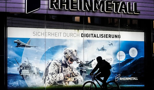 A man on a bicycle passes the headquarters of Germany's biggest arms manufacturer Rheinmetall AG in Duesseldorf, Germany, Monday, Jan. 23, 2023 (AP Photo/Martin Meissner)