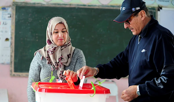 A Tunisian votes in the second round of the legislative elections in Tunis, Sunday, Jan. 29, 2023 (AP Photo/Hassene Dridi)