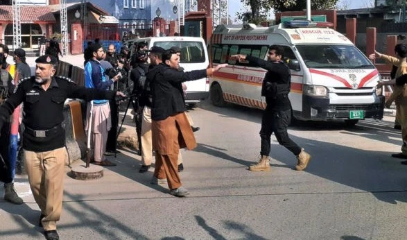 Police officers clear the way for ambulances carrying wounding people from the scene of a bomb explosion at a mosque in Peshawar, Pakistan, January 30, 2023.