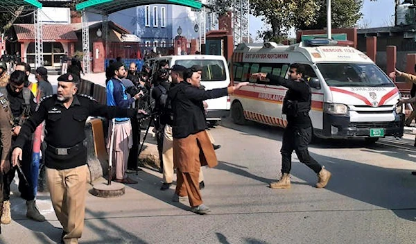 Police officers clear the way for ambulances carrying wounding people from the scene of a bomb explosion at a mosque in Peshawar, Pakistan, January 30, 2023.(AP)