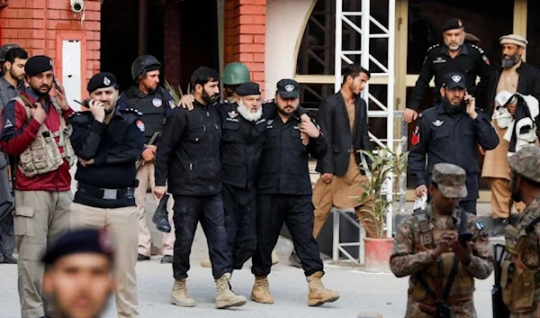 Police officers assist an injured officer, after a suicide blast in a mosque in Peshawar, Pakistan January 30, 2023 (Reuters).