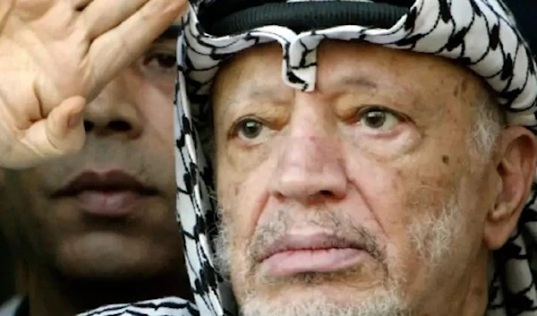 Former Palestinian president Yasser Arafat salutes during a rally at his headquarters in the West Bank September 14, 2003. (REUTERS).