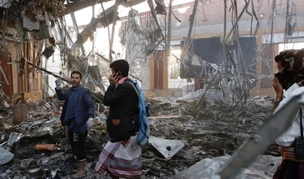 Yemeni men walk through a Sanaa building destroyed in a deadly Saudi-led coalition strike. (AFP)